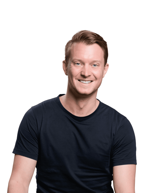 A smiling man with closely cropped hair wearing a black t-shirt against a white background.