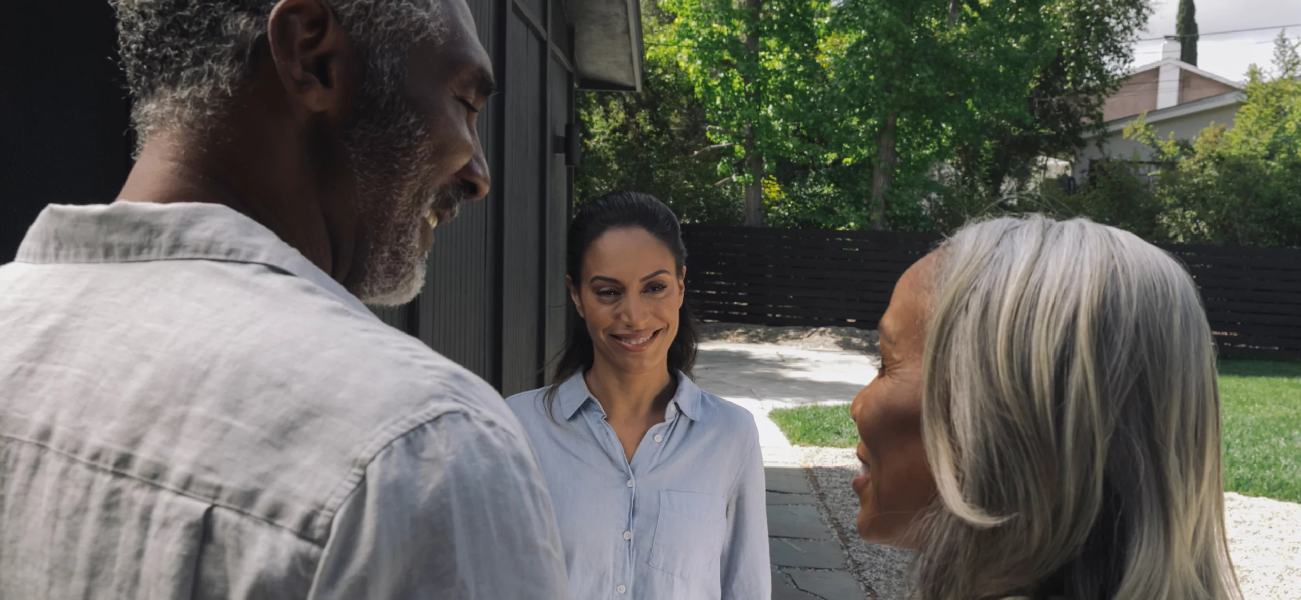 Generations unite: a joyful family moment as loved ones share a sunny reunion at the doorstep.